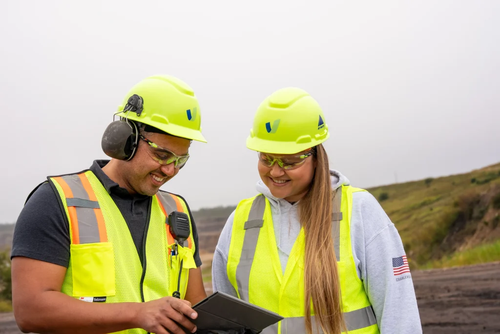 Environmental Product Declarations - two workers in hard hats and safety vests reviewing a tablet at a quarry