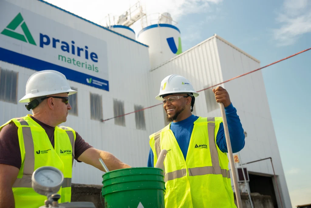 Regional Cement Suppliers - two Prairie Materials workers in hard hats and safety vests outside a Prairie Materials plant